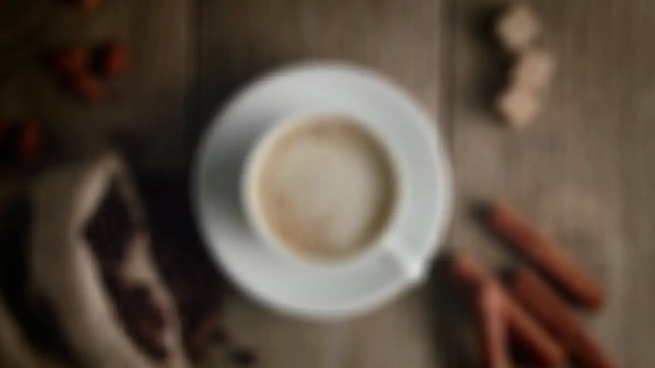 Cocoa is dusted through a stencil onto a cappuccino, revealing the La Selva Coffee logo